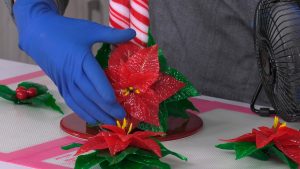 montaje-centro-navideño-caramelo-flor-de-pascua-hojas-de-acebo-rojo-blanco