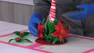 montaje-centro-navideño-caramelo-flor-de-pascua-hojas-de-acebo-rojo